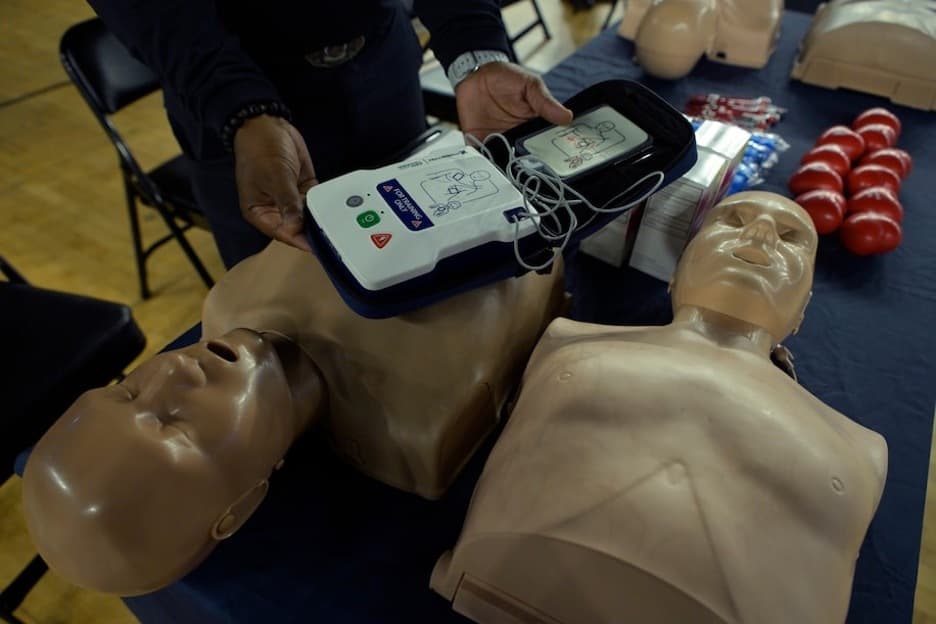 A classroom setting with CPR manikins and an AED.